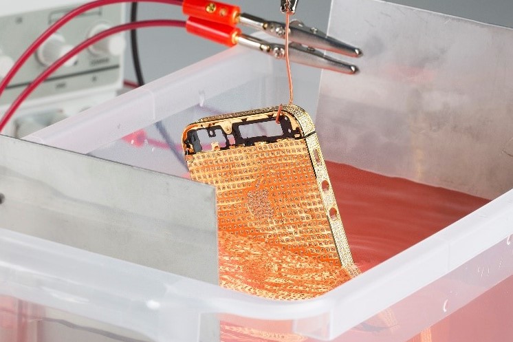 iPhone being suspended in 24k gold solution during electroplating