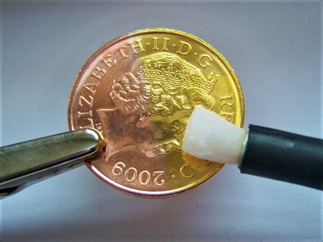 Two pence coin half copper, half gold plated via a pen plating probe with nib attached