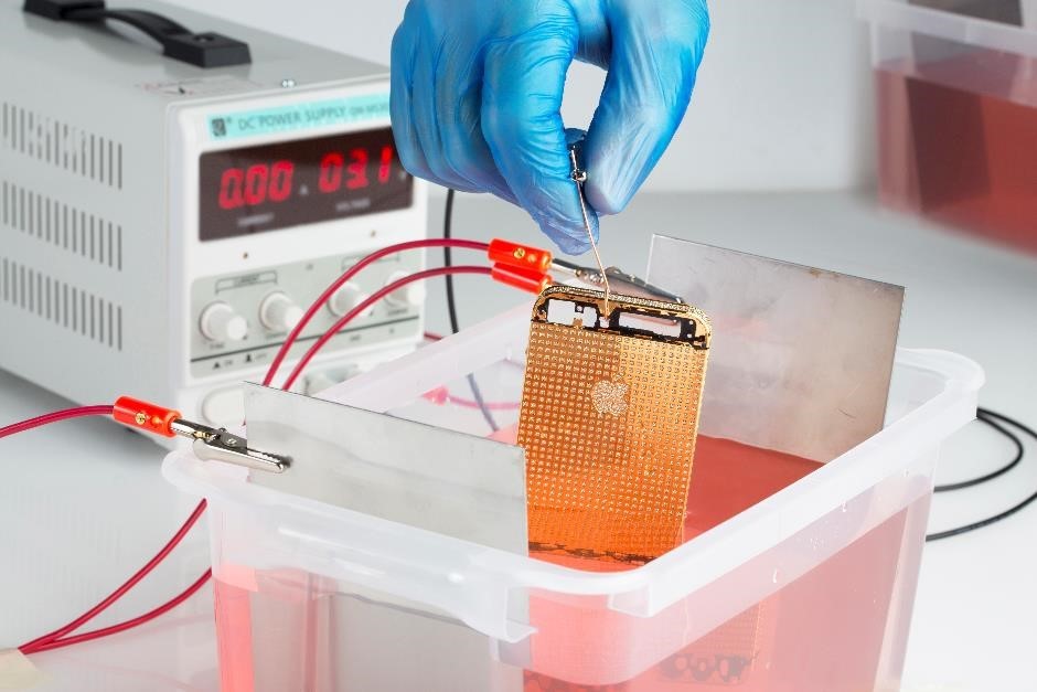 Gold plated iPhone in the process of electroplating via a plating tank